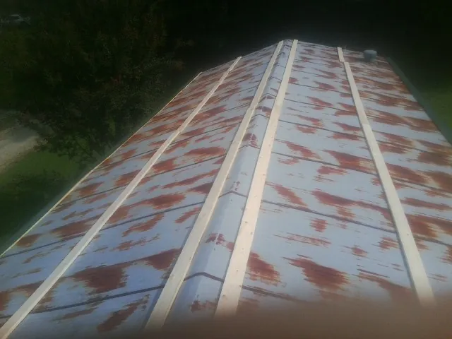 Rusted metal roof panels with new wood purlins before replacement — Storm Damage Roof Repair in Okahumpka by Roofing Brothers